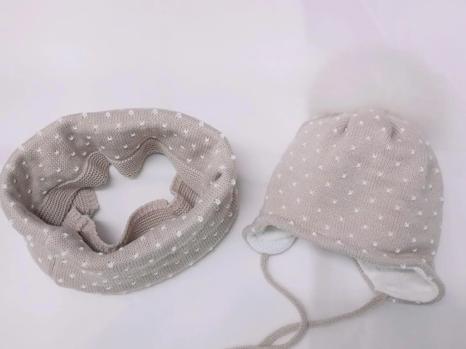 Conjunto de bebé de gorro y cuello en color Topo con topos de Jóse Luis Navarro.